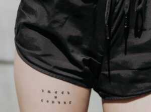 finos tatuajes pequeños en el muslo para mujeres